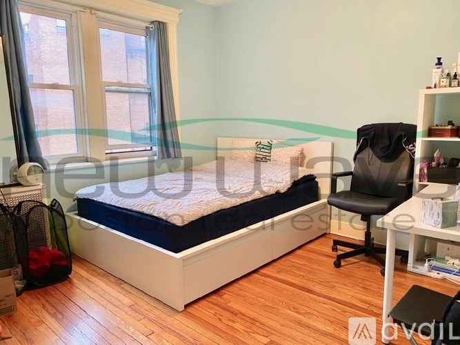 A bedroom with a bed, desk, and chair.
