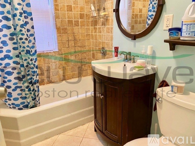 A bathroom with a brown cabinet and a white sink.