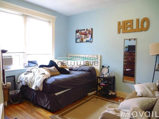 A bedroom with a bed, nightstand, and a wall hanging that says "HELLO".