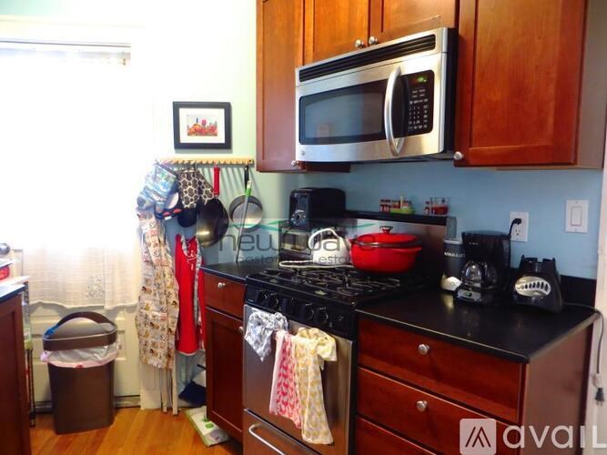 A kitchen with a black stove top and a black microwave above it.