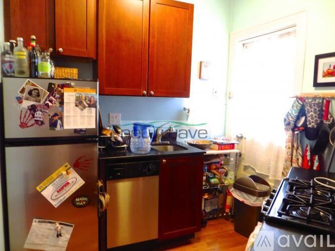 A kitchen with a refrigerator covered in magnets and papers.