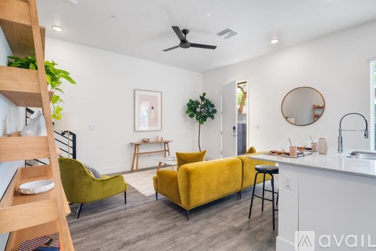 A living room with a yellow couch and a wooden shelf.