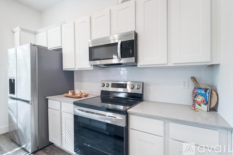 A kitchen with white cabinets and a black stove top.