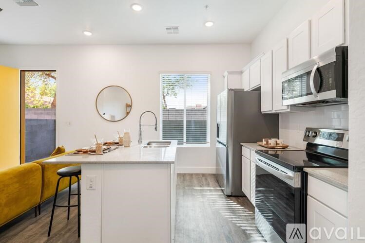 A kitchen with white cabinets and a yellow chair.