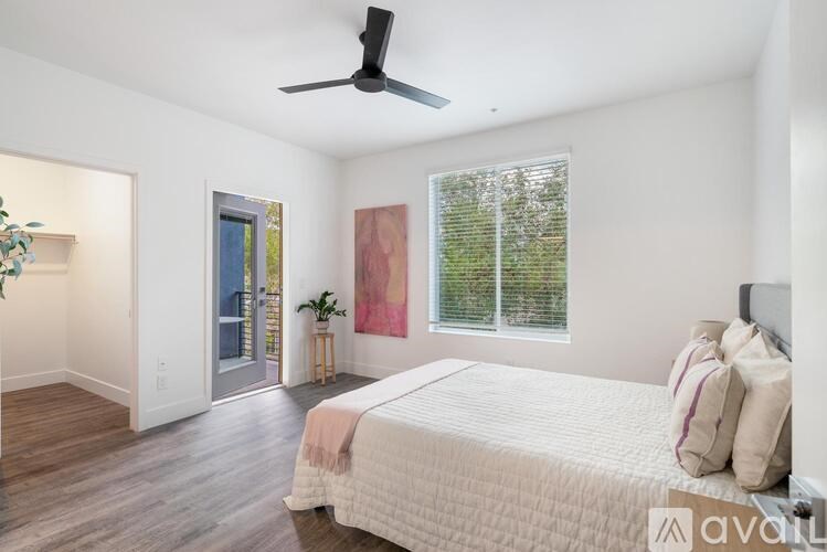 A bedroom with a bed, a ceiling fan, and a window with blinds.