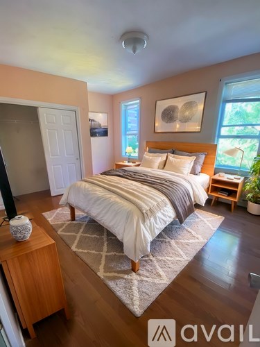 A bedroom with a bed, nightstand, and window.