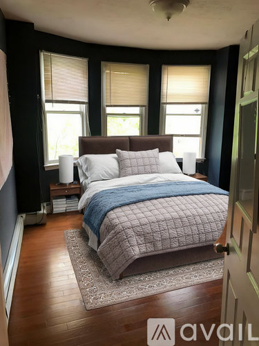A bedroom with a bed, pillows, and a blanket.