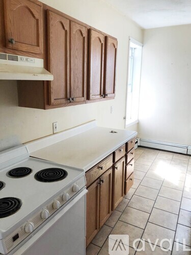 A kitchen with white appliances and wooden cabinets.