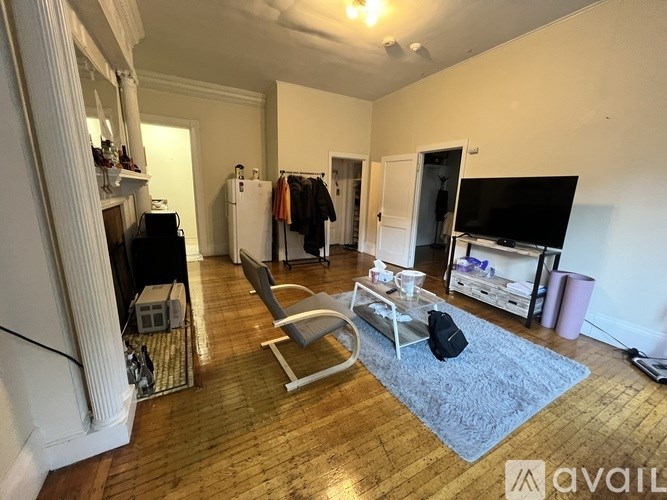 A living room with a grey rug and a white chair.