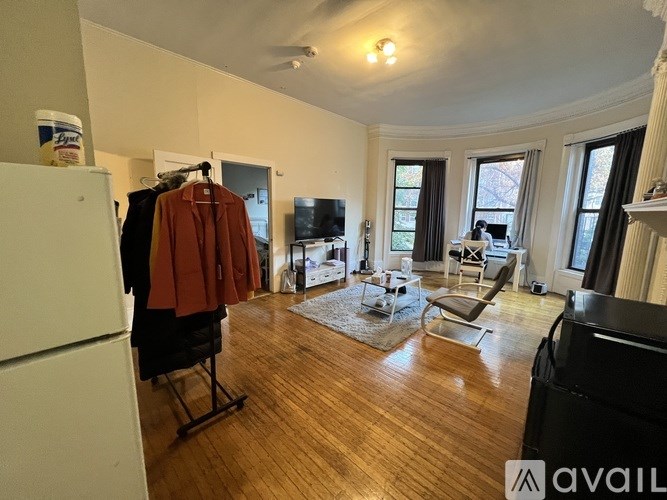 A living room with a brown coat hanging on a chair.