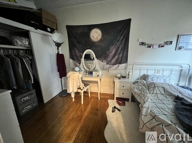 A bedroom with a bed, a vanity table with a mirror, and a wardrobe.