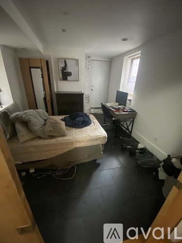 A bedroom with a bed, desk, and chair.