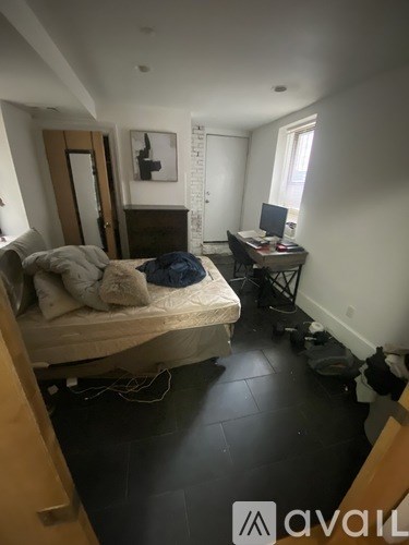 A bedroom with a bed, desk, and chair.