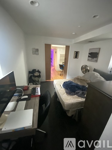 A room with a bed, desk, and computer.
