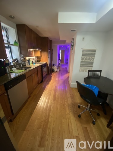 A kitchen with wooden floors and a dining area with a table and chairs.