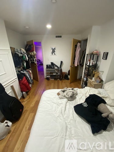 A bedroom with a bed, a wardrobe and a chair.