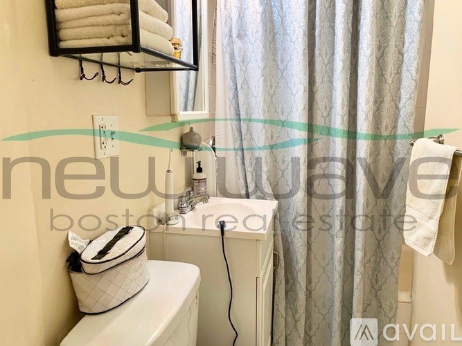 A white toilet with a white towel and a white bag on it.