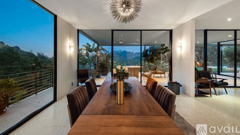 A modern dining room with a long wooden table and chairs.