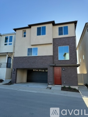 A two-story house with a red door and a garage.