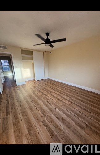 A room with wooden flooring and a ceiling fan.