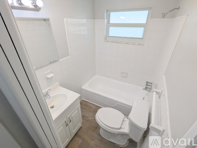 A white bathroom with a toilet, sink, and bathtub.