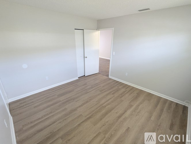 A room with wooden flooring and a white door.