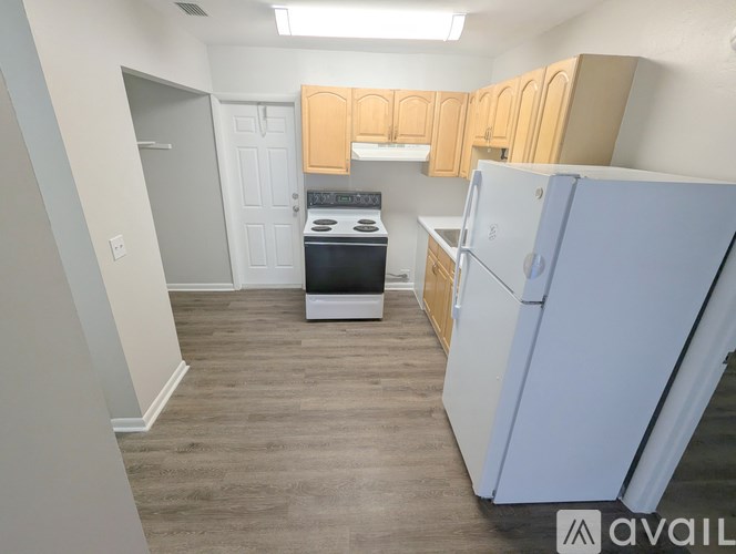 A kitchen with a white fridge and a white stove top oven.