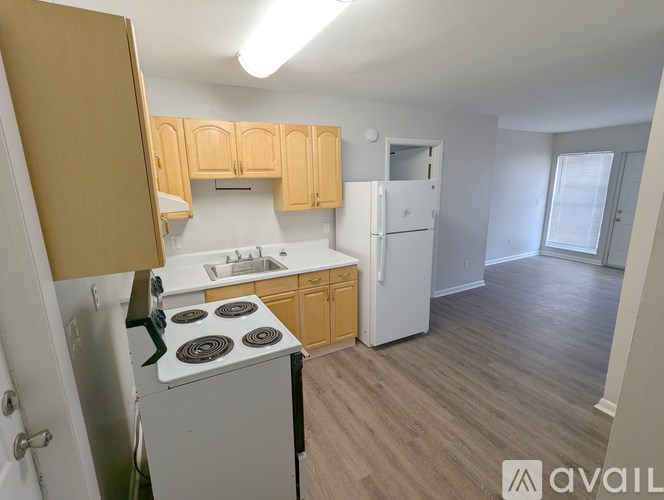 A kitchen with wooden cabinets and a white fridge.