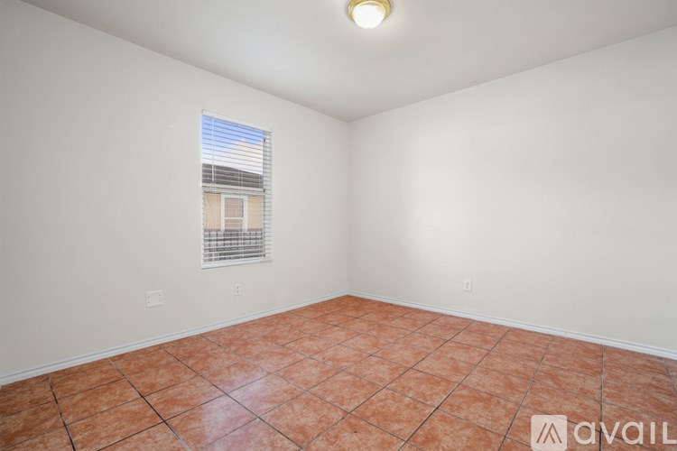 A room with a window and tiled floor.
