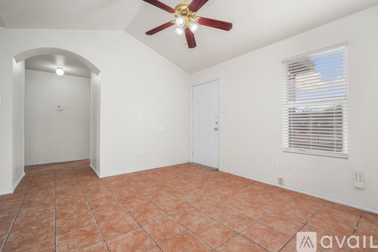 A room with a ceiling fan and tiled floor.