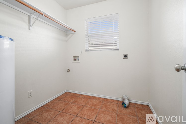 A room with a tile floor and a window with blinds.
