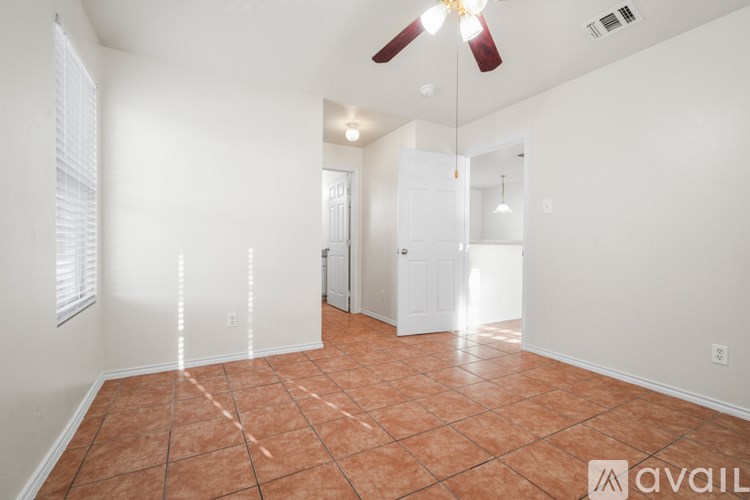A room with a ceiling fan and tile flooring.