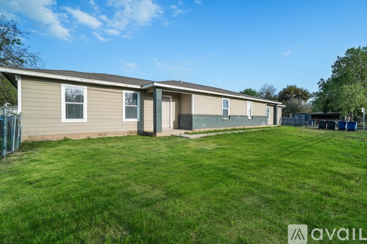 A grassy area in front of a building with a sign that says "available".