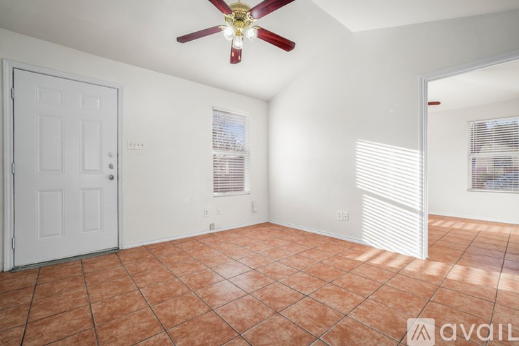A room with a ceiling fan and tiled floor.