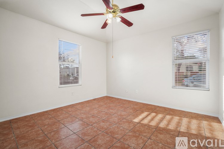 A room with a ceiling fan and tiled floor.