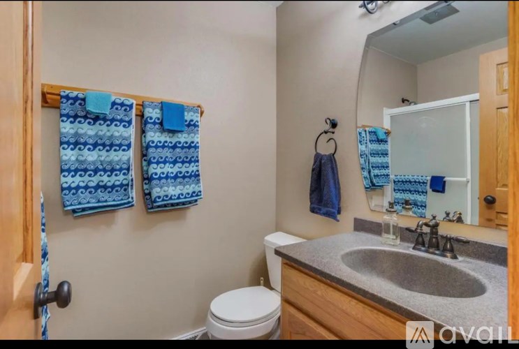 A bathroom with a toilet, sink, and mirror.