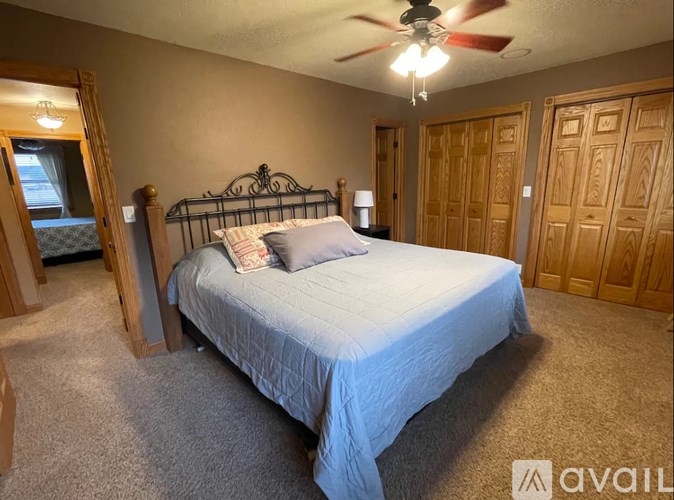 A bedroom with a bed, dresser, and mirror.