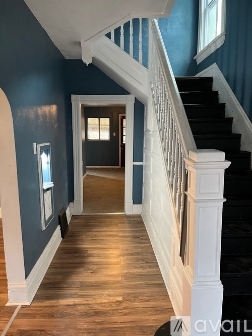 A hallway with a staircase and a doorway.