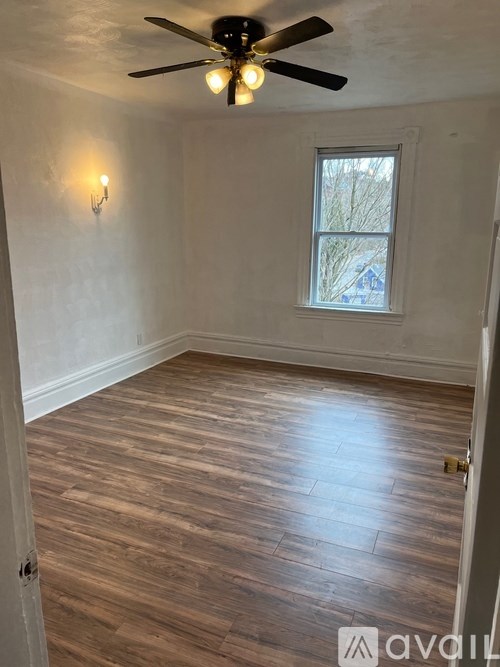 A room with a ceiling fan and a window.