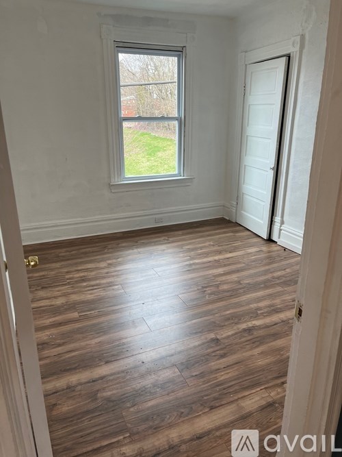 A room with wooden flooring and a window.