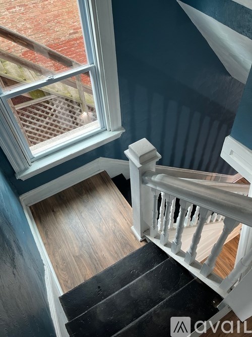 A staircase with a window and a wooden floor.