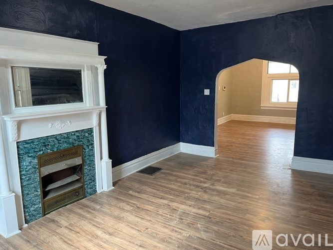 A room with a fireplace and a wooden floor.