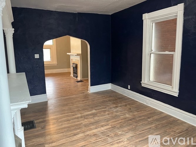 A room with dark blue walls and wooden flooring.
