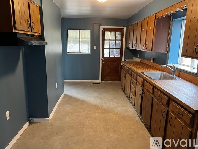 A kitchen with wooden cabinets and a countertop is available.