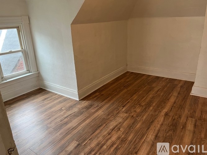 A room with wooden flooring and a window.