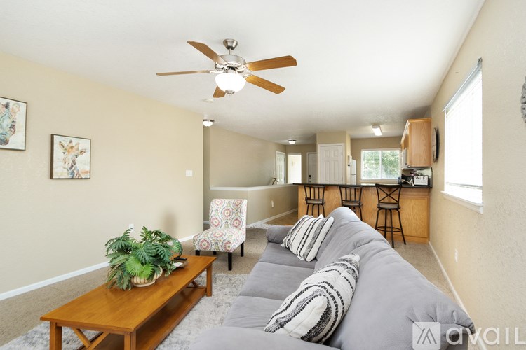 A living room with a grey couch and a wooden coffee table.
