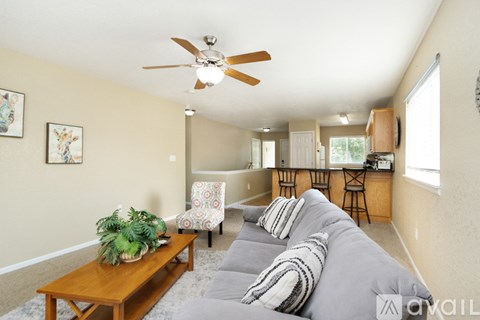 A living room with a grey couch and a wooden coffee table.