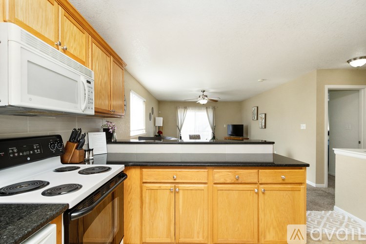 A kitchen with wooden cabinets and a black countertop.