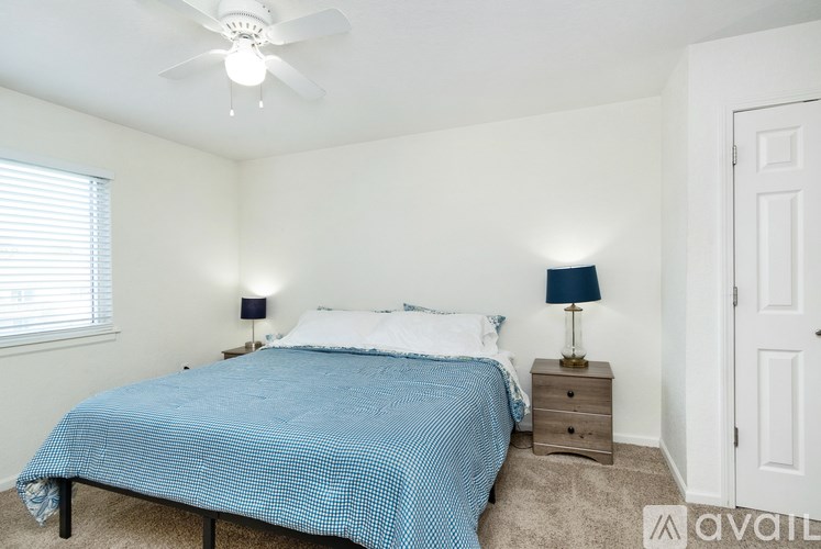 A bedroom with a bed, nightstand, and window.