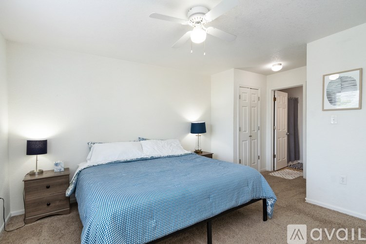 A bedroom with a bed, nightstand, and two lamps.